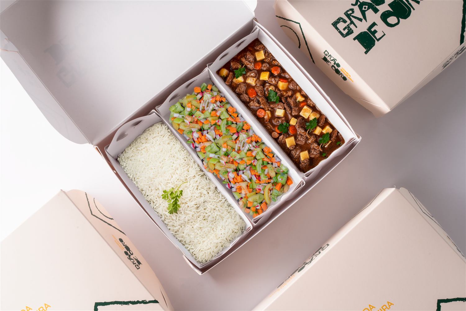 Caixa de delivery aberta com refeição completa, arroz, salada e carne, exemplo de embalagem para marmitas da Pluspack